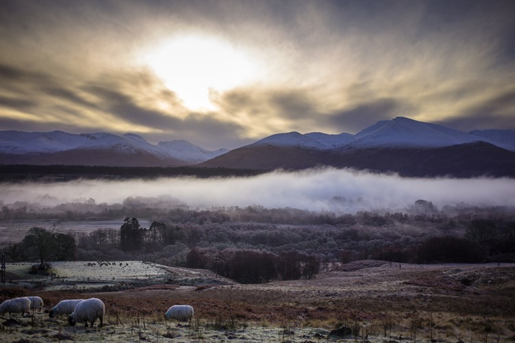 Morning fog in the Great Glen, Scotland, on a frosty winter morning, surrounded by mountains